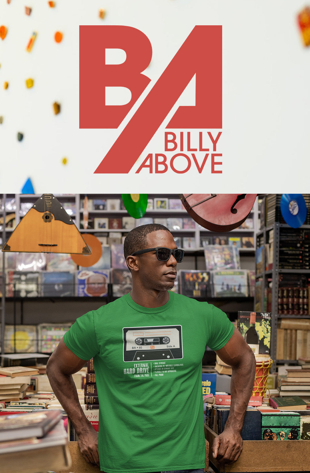 A man leaning and wearing a green shirt with an old cassette tape.
