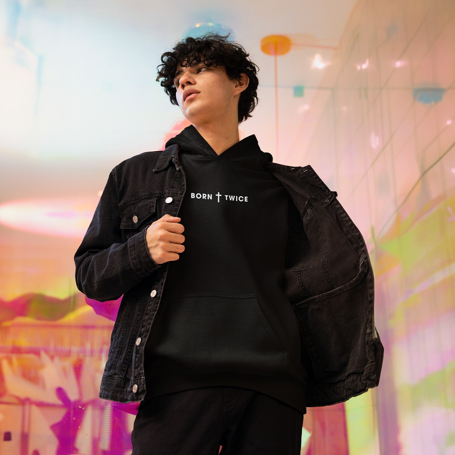 Image of A young person wearing a black Born Twice Hoodie