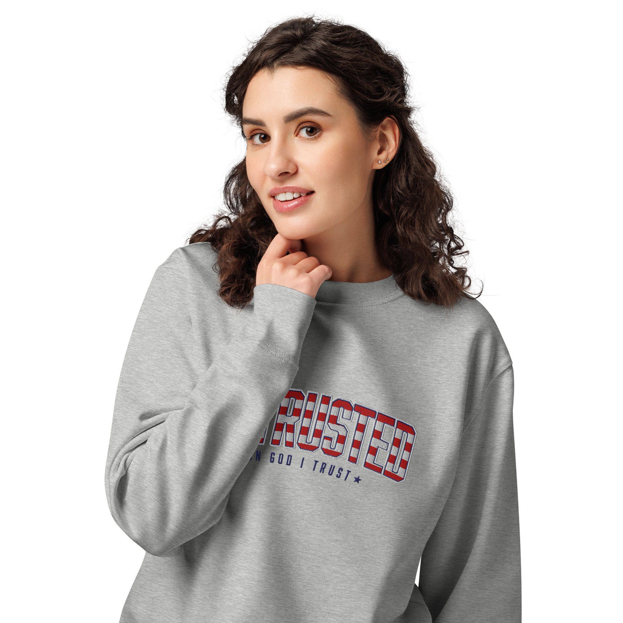 Image of Woman wearing the Heather Grey patriotic sweatshirt, close-up of the American flag ENTRUSTED In God I Trust design
