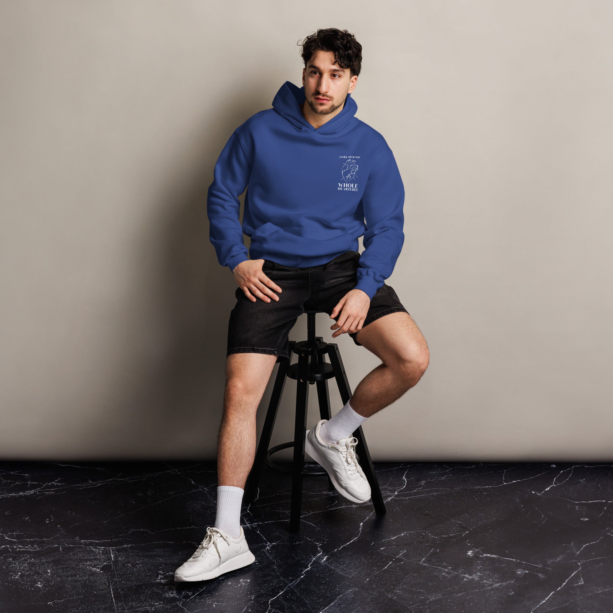 Image of Wholeheartedly Oversized Cobalt Christian hoodie lifestyle seated — Entrusted to Him faith streetwear